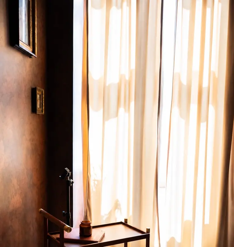 Tretmanska soba: lanene zavjese u toplom popodnevnom svjetlu, drveni stolić i parket u riblju kost.